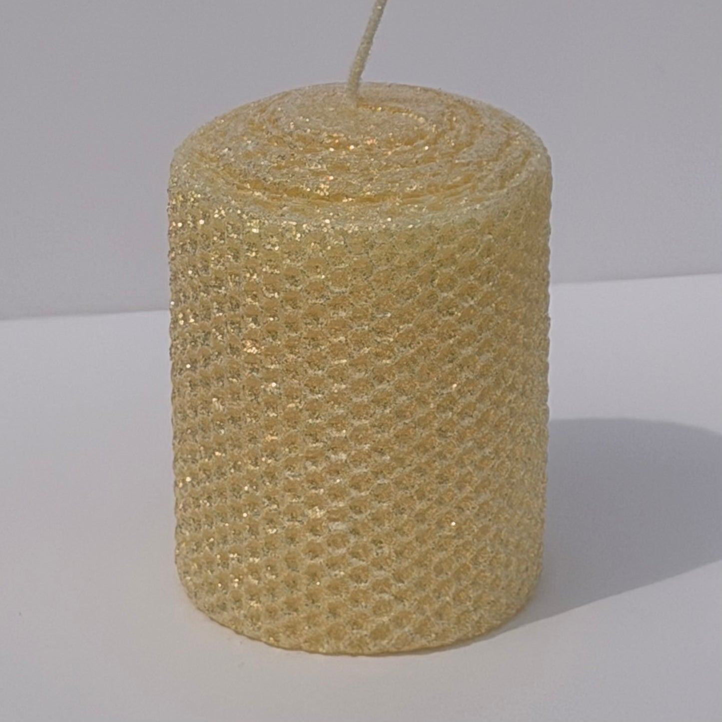 Our Antique White Limited Edition Candle is a timeless classic. Hand-rolled from natural beeswax, it exudes a delicate white with a antique, aged yellow undertone. Finished with a dusting of our classic iridescent glitter, it softly glimmers with a golden sheen, evoking a sense of vintage charm and quiet elegance.
