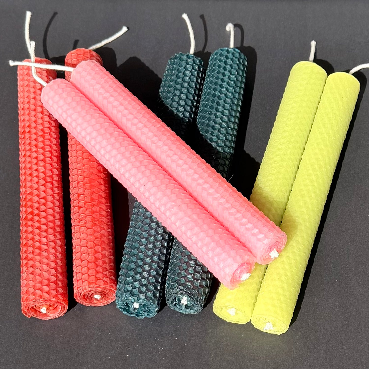 Our natural, unglittered, candles are made from 100% beeswax sheets and offered in a variety of colors all with the traditional honeycomb design to add to the beauty of the beeswax. Our candles are handmade, rolled by hand and made to order.