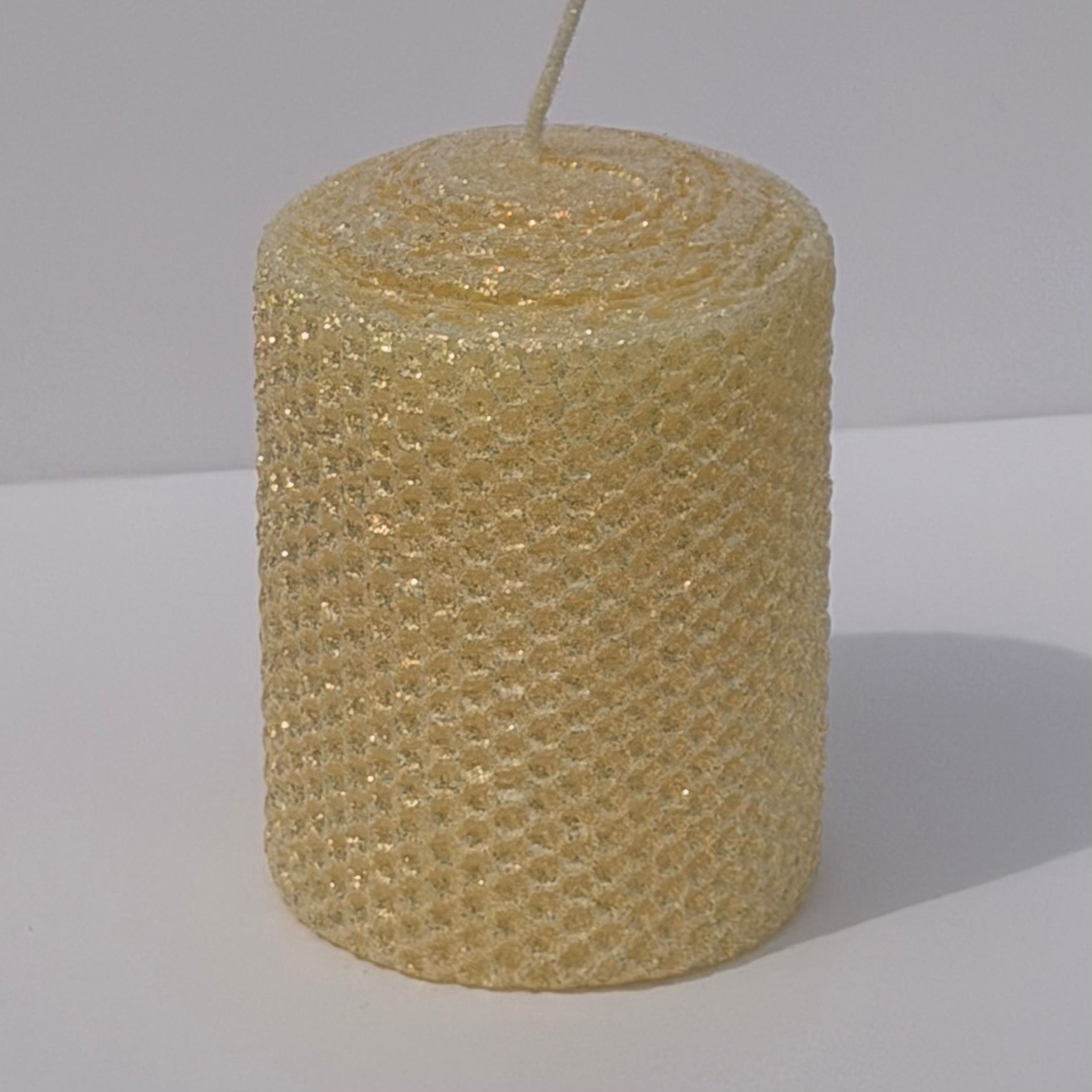 Our Antique White Limited Edition Candle is a timeless classic. Hand-rolled from natural beeswax, it exudes a delicate white with a antique, aged yellow undertone. Finished with a dusting of our classic iridescent glitter, it softly glimmers with a golden sheen, evoking a sense of vintage charm and quiet elegance.
