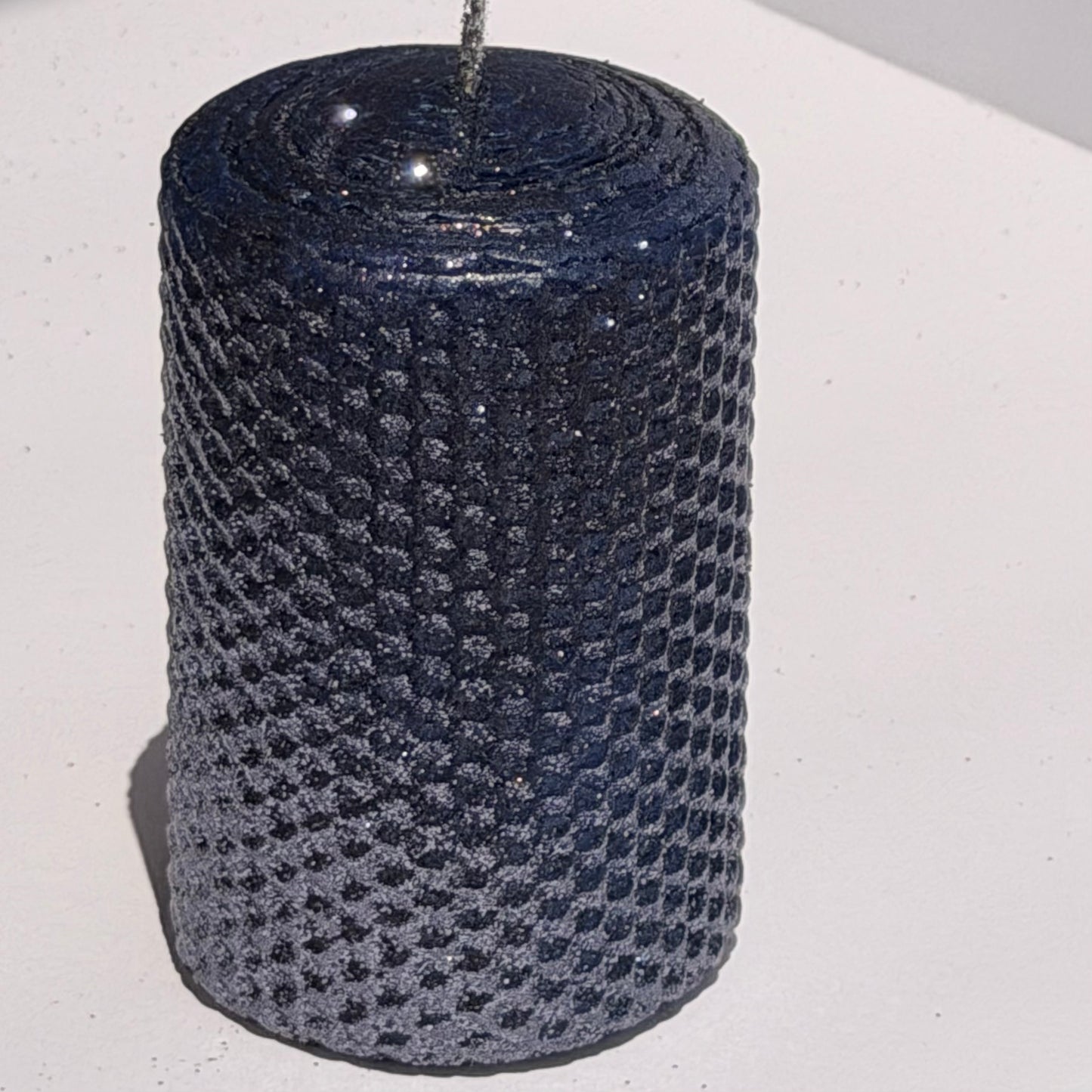 Illuminate your space with the regal beauty of our Black Sapphire Specialty Candle. Hand-rolled from our Bright Blue beeswax, each candle is adorned with a dusting of graphite metallic glitter, allowing the deep sapphire glow to shine through. With every flicker, it captures a bold, captivating elegance, perfect for special occasions or a touch of nighttime charm.
