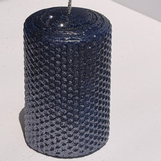 Illuminate your space with the regal beauty of our Black Sapphire Specialty Candle. Hand-rolled from our Bright Blue beeswax, each candle is adorned with a dusting of graphite metallic glitter, allowing the deep sapphire glow to shine through. With every flicker, it captures a bold, captivating elegance, perfect for special occasions or a touch of nighttime charm.