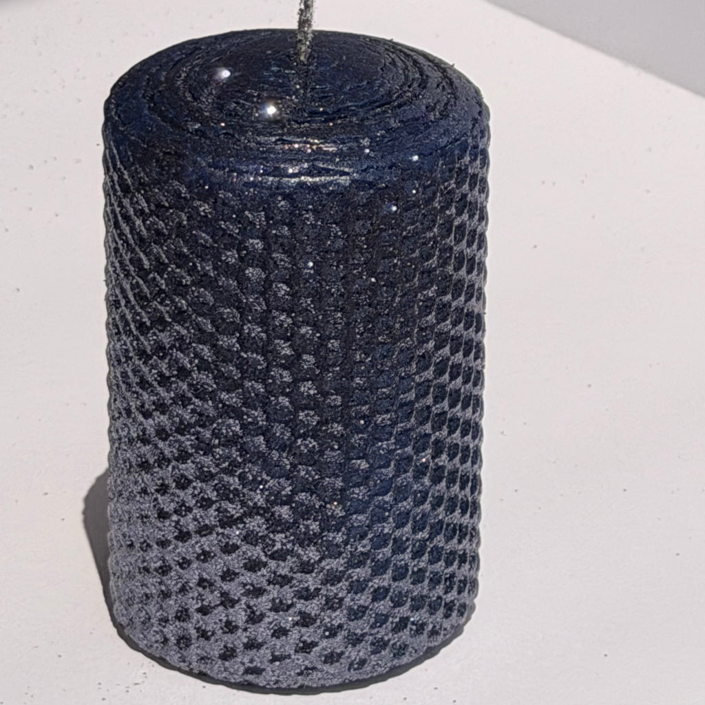 Illuminate your space with the regal beauty of our Black Sapphire Specialty Candle. Hand-rolled from our Bright Blue beeswax, each candle is adorned with a dusting of graphite metallic glitter, allowing the deep sapphire glow to shine through. With every flicker, it captures a bold, captivating elegance, perfect for special occasions or a touch of nighttime charm.