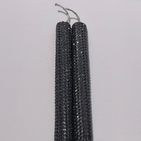 Add a touch of modern elegance with our Graphite Metallic Glitter Taper Candles. Inspired by the sleek depth of pencil lead, these candles are a rich graphite gray, coated in a dazzling metallic glitter that catches the light and enhances every subtle curve. Perfect for adding a refined, luminous accent to any dinner or special event.