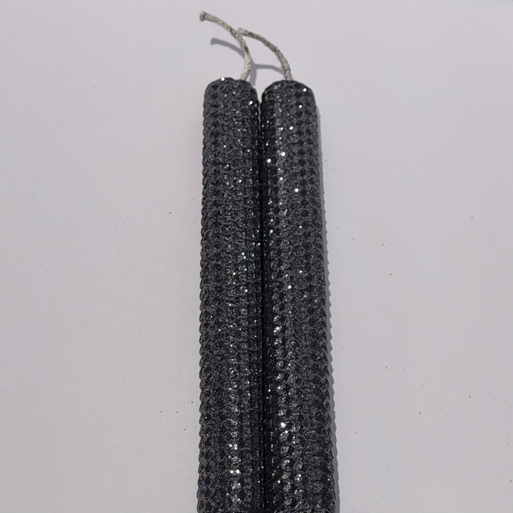 Add a touch of modern elegance with our Graphite Metallic Glitter Taper Candles. Inspired by the sleek depth of pencil lead, these candles are a rich graphite gray, coated in a dazzling metallic glitter that catches the light and enhances every subtle curve. Perfect for adding a refined, luminous accent to any dinner or special event.