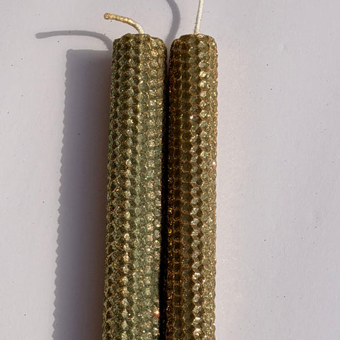 Embrace the essence of autumn with our Fall Brass Specialty Candle. Hand-rolled from olive green beeswax, this candle is crowned with a fine dusting of brass metallic glitter, letting the rich green glow softly beneath. Perfect for adding a subtle shimmer and a warm, seasonal charm to any event or gathering.