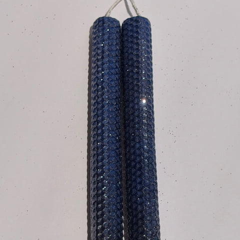 Illuminate your space with the regal beauty of our Black Sapphire Specialty Candle. Hand-rolled from our Bright Blue beeswax, each candle is adorned with a dusting of graphite metallic glitter, allowing the deep sapphire glow to shine through. With every flicker, it captures a bold, captivating elegance, perfect for special occasions or a touch of nighttime charm.