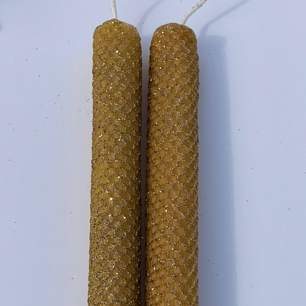 Illuminate your space with our Mercury Specialty Candle, hand-rolled from pure golden beeswax. This radiant candle is adorned with a delicate dusting of metallic glitter, a shimmering blend of silver and gold, allowing the warm glow of beeswax to peek through. Perfect for adding a touch of celestial elegance to any evening.