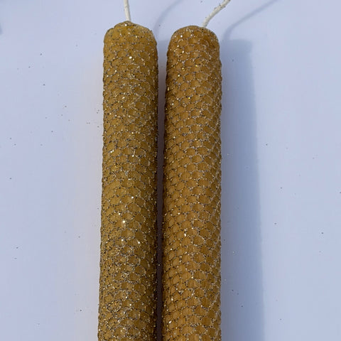 Illuminate your space with our Mercury Specialty Candle, hand-rolled from pure golden beeswax. This radiant candle is adorned with a delicate dusting of metallic glitter, a shimmering blend of silver and gold, allowing the warm glow of beeswax to peek through. Perfect for adding a touch of celestial elegance to any evening.