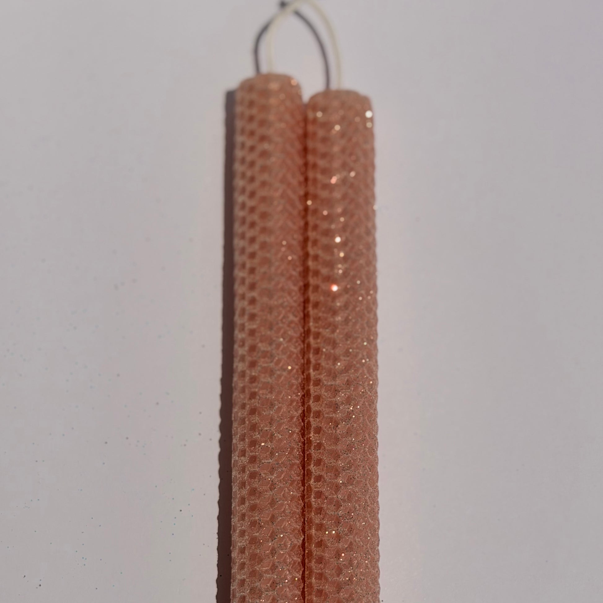 Our Blush Limited Edition candle is a delicate whisper of romance. Hand-rolled from pure beeswax it glows in a soft blush pink, with a subtle beige undertone. Dusted with our classic iridescent glitter, it catches the light with a gentle gold shimmer, adding a touch of timeless elegance to any space.